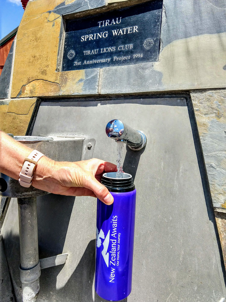 reusable water bottle being filled at water fountain